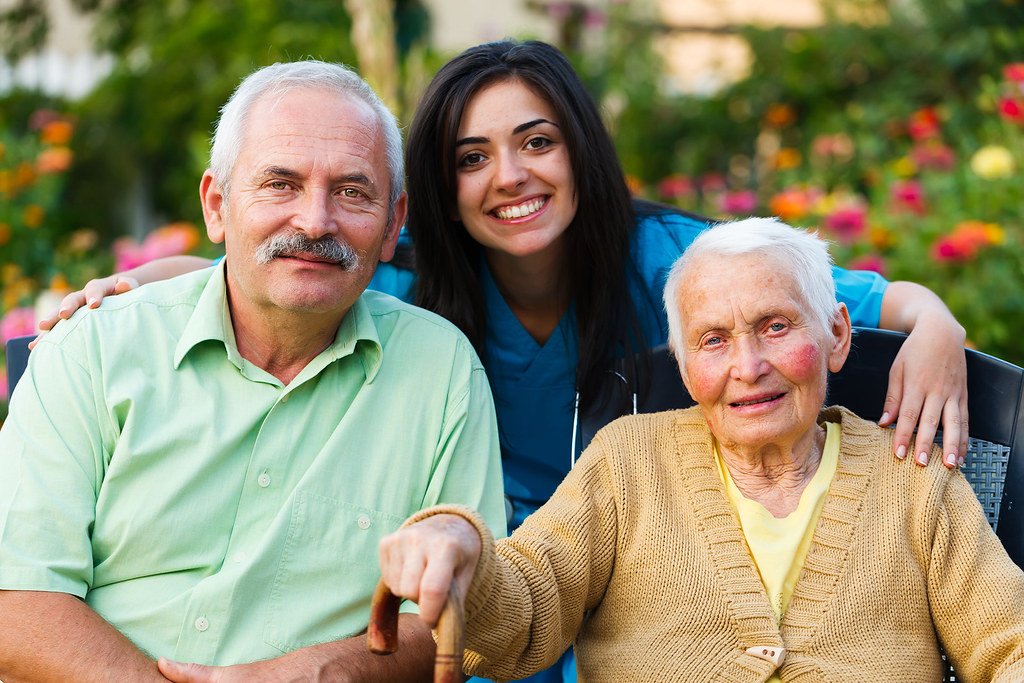 Caregiver with a senior woman and her son outdoors