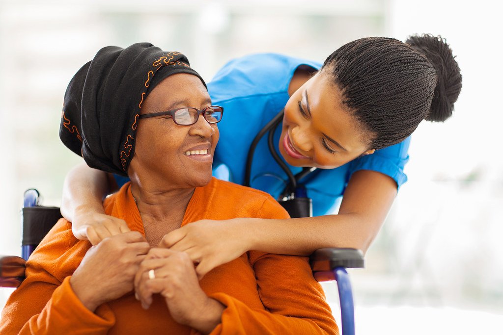 Caregiver hugging a smiling senior woman