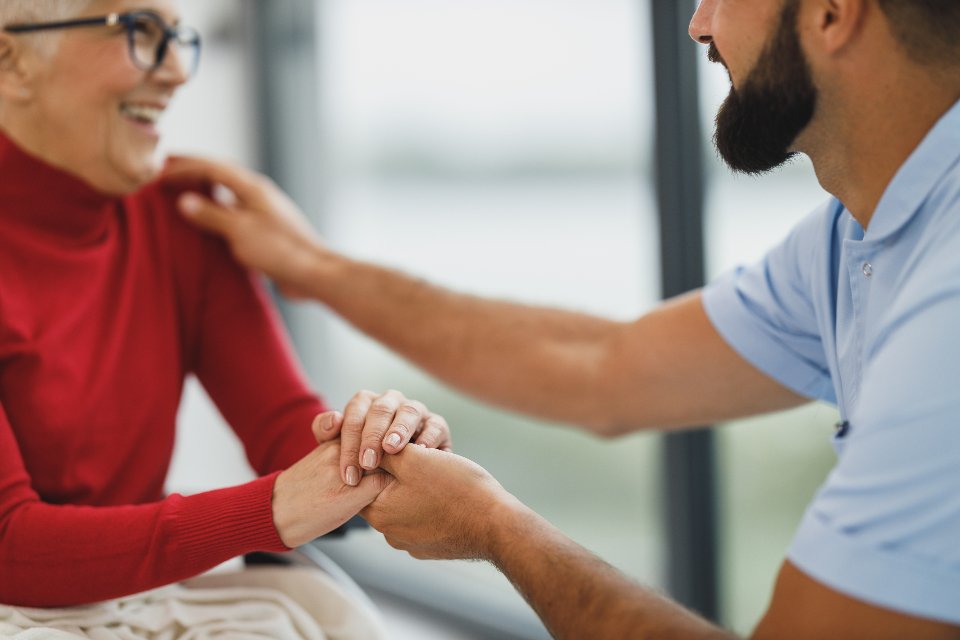 Caregiver holding a senior woman's hand